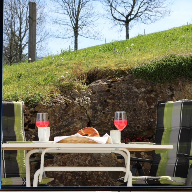 Terrasse mit Frühstück Terrasse der Ferienwohnung Neyer in Steibis mit Frühstückstisch und Morgensonne – Auszeit im Allgäu mit Blick ins Tal.